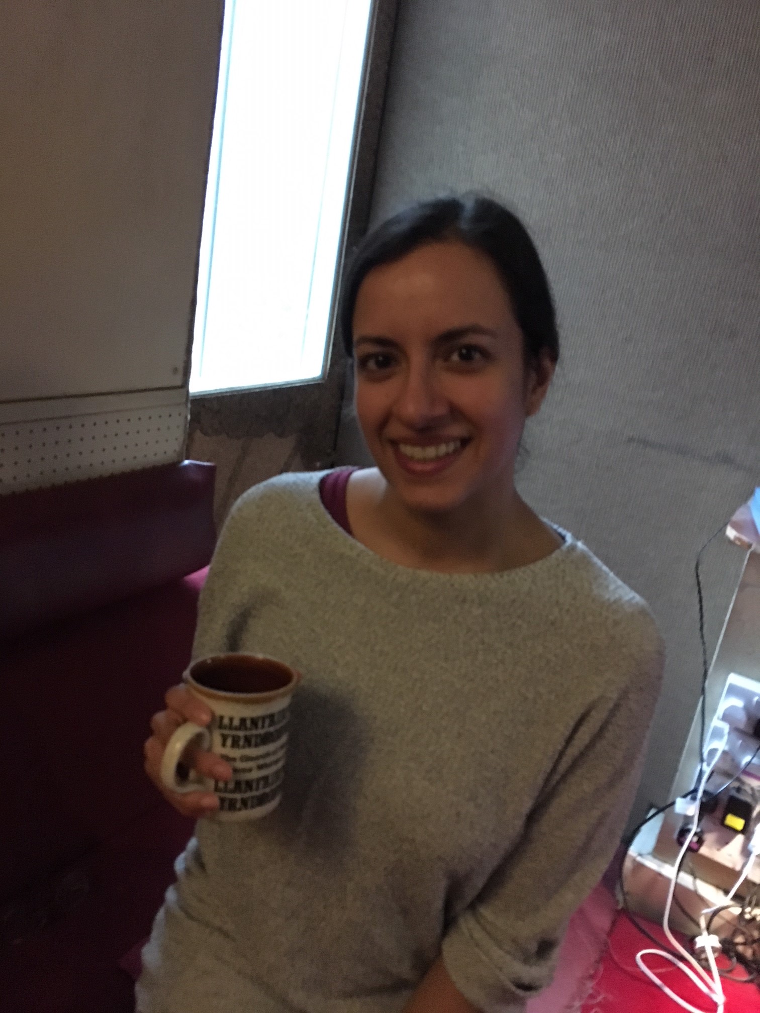 Avita after the recording session holding a mug of tea and smiling